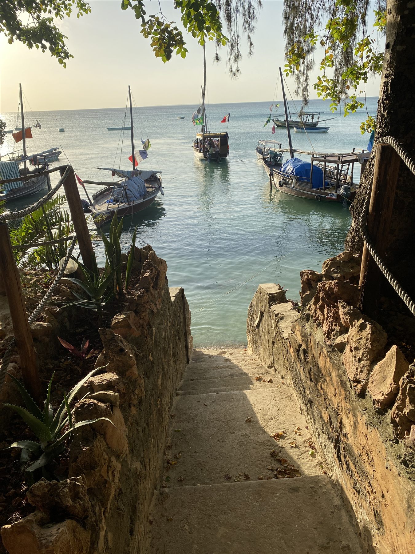 Old coral stone walls and fishing boats on the Stone Town waterfront